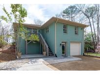 Charming home featuring a wooden deck, attached garage, and landscaped yard with trees at 1900 Sunset Ave, Durham, NC 27705
