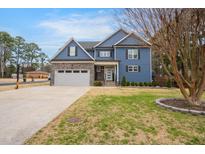 Two-story home featuring blue siding, stone accents, and well-maintained lawn, creating a welcoming curb appeal at 206 Hamby St, Clayton, NC 27520