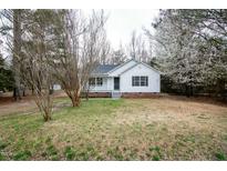 Charming single-story home with white siding, a cozy front porch, and a well-maintained yard at 228 Duck Pond Ln, Clayton, NC 27520