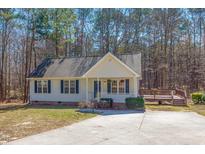 Charming single-story home features a welcoming front porch, black shutters, and lovely landscaping at 35 Ebbets Ct, Youngsville, NC 27596