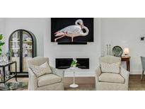 Elegant living room features fireplace with flamingo art above, two chairs, and curated decor at 4007 Southpoint Landing Way, Durham, NC 27707
