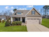 Charming single-Gathering home features a manicured lawn, inviting front porch, and two-car garage at 420 Carsons Creek Trl, Wendell, NC 27591