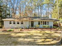 Charming single-story home with manicured lawn, mature trees, and inviting front entrance at 514 Caswell Rd, Chapel Hill, NC 27514