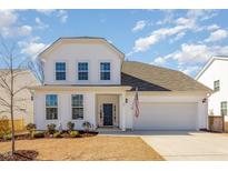 Charming two-story white home with a two-car garage, landscaped yard, and an American flag at 60 Silent Brook Trl, Franklinton, NC 27525