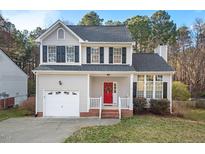 Charming two-story home with a well-maintained lawn, attached garage, and red front door at 7 Dardanelle Ln, Durham, NC 27713