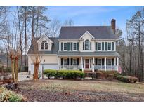 Inviting two-story home featuring a charming front porch with classic columns and a well-manicured landscaped yard at 721 Thompson Rd, Garner, NC 27529