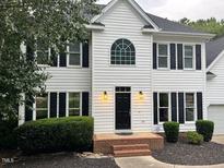 Charming white two-story home with black shutters and manicured landscaping at 725 Littleleaf Ct, Holly Springs, NC 27540