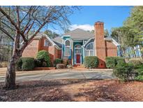 Charming two-story home featuring a red brick facade, blue accents, and a well-manicured front yard at 725 Thompson Rd, Garner, NC 27529