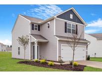 Charming two-story home with gray siding, a well-manicured lawn, and an attached two-car garage at 809 Rhino Bnd, Oxford, NC 27565