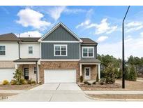 Charming two-story townhome featuring a brick facade, attached garage, and well-maintained landscaping at 1000 Pyrenees Way, Cary, NC 27519