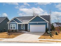 Charming single-Gathering home with a two-car garage, a stone foundation accent, and a well-manicured lawn at 1009 Grey Flint Pl, Mebane, NC 27302