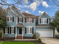 Charming two-story home with blue siding, black shutters, and well-manicured lawn at 104 Deep Gap Run, Cary, NC 27519
