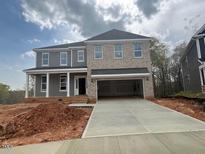 Newly constructed two-story home boasts a light brick facade and a spacious two-car garage at 124 Hemlock Falls Trl # 189, Raleigh, NC 27603