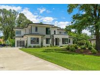 Beautiful modern home with lush green lawn and a long driveway leading to a two-car garage at 132 Edward Booth Ln, Durham, NC 27713