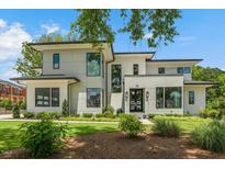 Contemporary two-story home featuring a meticulously landscaped front yard and modern architectural details at 132 Edward Booth Ln, Durham, NC 27713