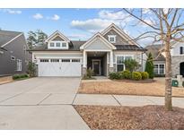 Charming home with a manicured front yard, white garage doors, and inviting front porch with stone accents at 1336 Santa Lucia St, Wake Forest, NC 27587