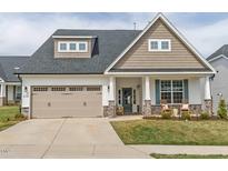 Charming home featuring a two-car garage, covered entry, and manicured landscaping with stone accents on the facade at 2059 Dowell Ct, Burlington, NC 27215