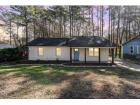 Charming single-story home with a brick facade, blue door, and covered front porch at 2409 Keith Dr, Raleigh, NC 27610