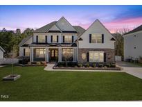 Beautiful two-story home with a landscaped front yard, stone accents, and classic architectural details at 2632 Jordan Pointe Blvd, New Hill, NC 27562