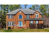Stately brick home featuring a symmetrical facade, blue front door, and well-manicured lawn at 4225 Old Lewis Farm Rd, Raleigh, NC 27604