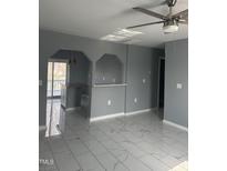 Open-concept living area featuring white tile flooring, stylish arches, and view of kitchen at 513 Woods St, Durham, NC 27703