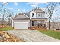 Charming two-story home with a covered porch and two-car garage nestled in a wooded setting at 5507 Eagles Nest Trl, Snow Camp, NC 27349