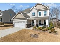Charming two-story home with a manicured front yard, covered porch, and attached two-car garage at 63 Capewood Ct, Garner, NC 27529