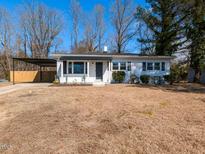 Charming single-story home with white siding, covered parking and neatly kept front yard at 823 Elmira Ave, Durham, NC 27707