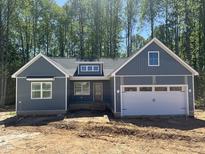 New construction home showing charming curb appeal with board and batten siding and two car garage at 9231 Bear Run Ln, Middlesex, NC 27557