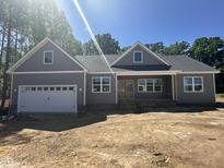 New construction featuring gray siding, white trim, a two-car garage and a covered front porch at 9235 Bear Run Ln, Middlesex, NC 27557