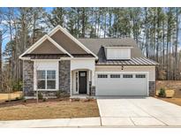 Charming single-Gathering home with a stone and siding exterior, attached garage, and manicured front yard at 95 Hornbeam Rd, Youngsville, NC 27596