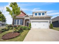 Beautiful home featuring a two-car garage, stone accents, and a well-manicured lawn and landscaping at 1 Parker Pond Ct, Durham, NC 27703