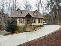 Charming home featuring dormer windows, a screened front porch, and a circular driveway at 1121 Tallyho Trl, Chapel Hill, NC 27516