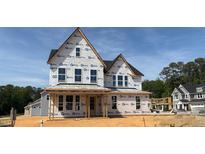 Two-story house under construction featuring a gable roof, multiple windows, and a framed porch, set against a blue sky at 3200 Balcon Ct # 28, Angier, NC 27501