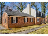 Charming brick home featuring black shutters, a black roof, and a well-maintained landscape at 350 W Lake Trl, Mebane, NC 27302