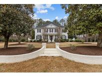 Elegant white home featuring classic design elements and a beautifully landscaped front yard at 101 Settlecroft Ln, Holly Springs, NC 27540