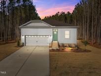 Charming one story home featuring a neutral exterior, attached two car garage, and manicured front yard at 10405 Hamish Dr, Zebulon, NC 27597