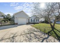 Charming home featuring an attached garage, long driveway, and a well-maintained front yard at 112 Theophilous, Holly Springs, NC 27540