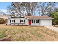 Charming home with a red front door, garage, and well-maintained lawn at 1206 Dubose St, Garner, NC 27529