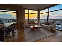 Bright living room featuring hardwood floors, large windows, and neutral-colored furniture for a relaxing atmosphere at 122 N Harrington St # 1105, Raleigh, NC 27603