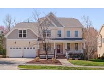 Charming two-story home boasting a welcoming front porch and well-manicured lawn on a sunny day at 2006 Mill Gate Ln, Cary, NC 27519