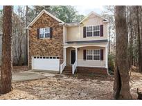 Charming two-story home with a stone facade and inviting front porch at 202 River Hills Dr, Clayton, NC 27527