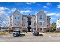 Attractive apartment complex with assigned parking spaces and well-maintained landscaping under a bright, partly cloudy sky at 2520 Friedland Pl # 102, Raleigh, NC 27617