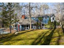 Charming two-story home with a red door, lots of light and a beautifully landscaped moss-covered yard at 2819 Meacham Rd, Chapel Hill, NC 27516