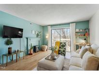 Inviting living room with a fireplace, bright walls, and large sliding doors to an outdoor balcony at 311 Swift Ave Ave # 202, Durham, NC 27705