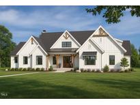 Charming two-story modern farmhouse with inviting front porch and beautifully landscaped front yard at 4060 Granite Ridge Trl, Raleigh, NC 27616