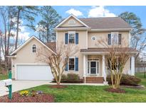Charming two-story home boasts blue shutters, a well-maintained lawn, and an attached two-car garage at 5 Piney Park Ln, Durham, NC 27713