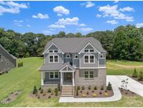 Beautiful two-story home with gray siding, manicured lawn, and inviting front entrance at 9004 Penny Rd, Raleigh, NC 27606