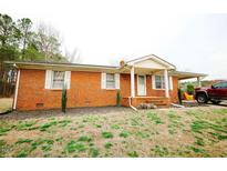 Charming brick home featuring a covered porch and carport on a well-maintained lot at 10166 Buffalo Rd, Clayton, NC 27527