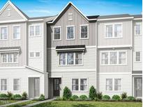 Attractive townhome featuring a mix of white and gray siding, complemented by lush green grass at 1031 Zelkova Lane, Chapel Hill, NC 27517